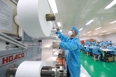LUANNAN COUNTY, Hebei Province, China-April 23, 2020: Workers are busy on the production line in a Medical mask factory.のeditorial素材
