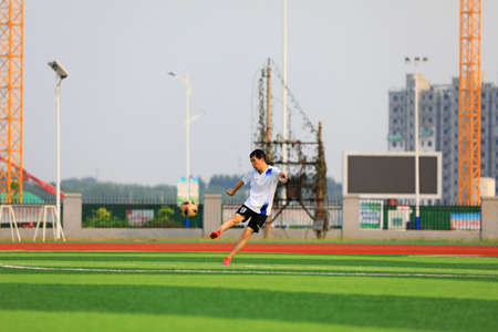 LUANNAN COUNTY, Hebei Province, China-August 23, 2020: Young people are playing football on the lawnのeditorial素材