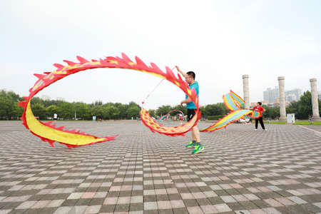 LUANNAN COUNTY, Hebei Province, China-August 4, 2020: People shake colored silk to keep fit in the parkのeditorial素材