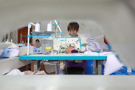 LUANNAN COUNTY, Hebei Province, China-April 8, 2020: The workers are busy on the production line in a garment factory.のeditorial素材