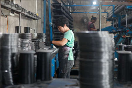 LUANNAN COUNTY, Hebei Province, China-August 20, 2020: Workers operate mechanical textile fishing...