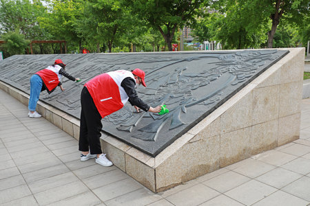 Young volunteers wipe city sculptures in the park.のeditorial素材