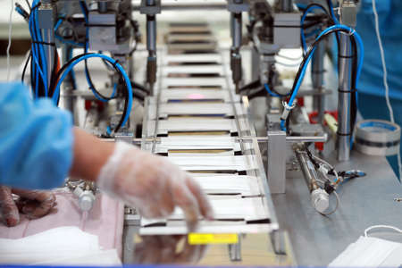 Workers are busy on the production line in a Medical mask factory.