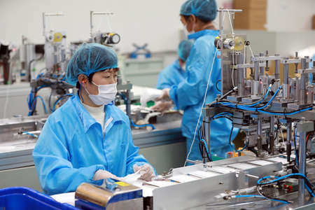LUANNAN COUNTY, Hebei Province, China-April 23, 2020: Workers are busy on the production line in a Medical mask factory.のeditorial素材