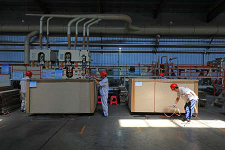 LUANNAN COUNTY, Hebei Province, China-September 4, 2020: Workers in the packaging board products in the production lineのeditorial素材