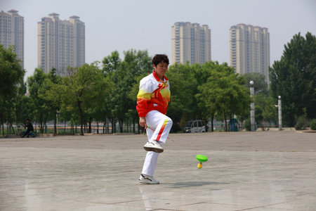 Tangshan City, Hebei Province, China - May 11, 2019: A lady is practicing diabolo in the park.のeditorial素材