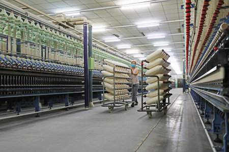 LUANNAN COUNTY, Hebei Province, China - March 18, 2020: The female worker is busy on the production line in a spinning factory.のeditorial素材