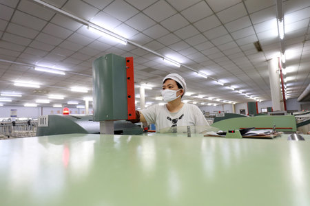LUANNAN COUNTY, Hebei Province, China - March 18, 2020: The female worker is busy on the production line in a spinning factory.のeditorial素材