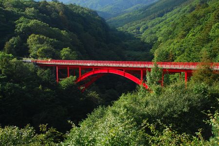 Red steel bridge in mountainの写真素材