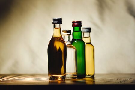 different alcohol bottles are on the table on a light background.の写真素材