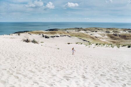 Smiling young girl on a sand dune near the Baltic Seaの写真素材