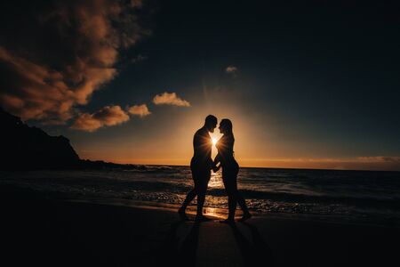a man makes an offer with a wedding ring to his girlfriend on the sea beach. sunset romantic i said yesの写真素材