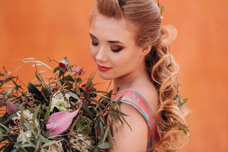 A young model girl in a beautiful dress with a bouquet of flowers in the countryside in France. Girl with flowers in the spring Provence villageの写真素材