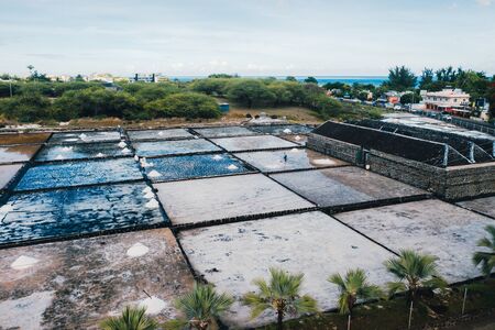 People collect the salt on a Sunny day on the shores of the Indian ocean in Mauritius.の写真素材