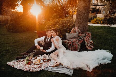 Dinner the Bridal couple at the picnic.A couple is relaxing at sunset in France.Bride and groom on a picnic in Provence.の写真素材