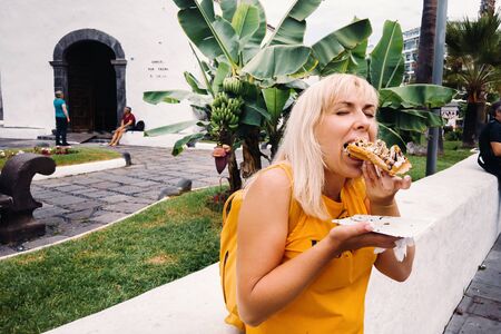 a girl travels and eats hot ice cream on the street.A girl eats on the street of the old city of Tenerife.の写真素材