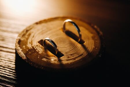 Close-up of two gold wedding rings lying in a wooden bar.Wedding ring.Wedding ring.Wedding.の写真素材