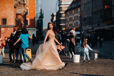 A bride in a wedding dress with long hair in the old town of Wroclaw. Wedding photo shoot in the...
