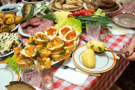 A lot of different food on the Banquet table and served boiled potatoes with dill.A large number of...