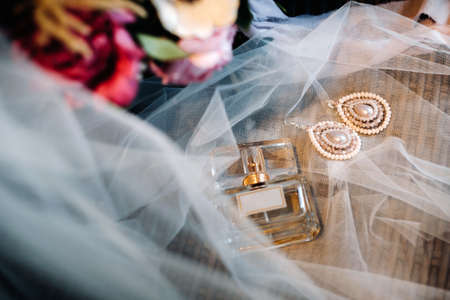 Accessories for the bride. Earrings on the veil. White wedding earrings. Space for text and ads.