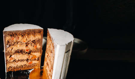 Amazing Cakes. Sliced chocolate wedding cake cake with amazing filling on a black background.Large cake in white chocolate.の写真素材