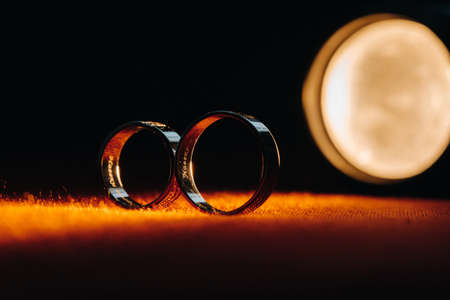 Two wedding rings on a red background. Gold rings of a couple in love.Concept of love.Wedding ring.の写真素材