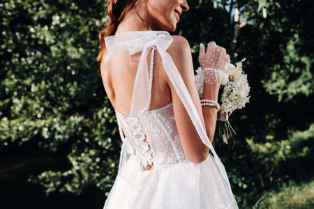 portrait of an elegant bride in a white dress with a bouquet in nature in a nature Park.Model in a...