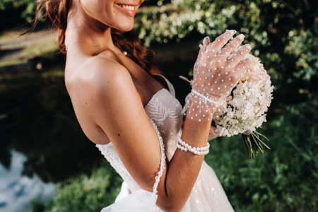 portrait of an elegant bride in a white dress with a bouquet in nature in a nature Park.Model in a...