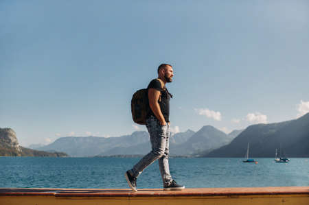 Male traveler with a backpack on the background of Alpine mountains and lakes. Vacation in the Alps.Austriaの写真素材