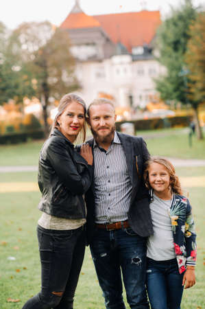 A happy family of three runs through the grass in Austrias old town.A family walks through a small town in Austria.Europe.Velden am werten Zeeの写真素材