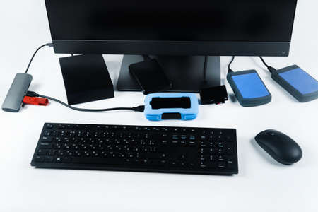 Multiple external hard drives connected to a monoblock on a white background.Computer with hard...