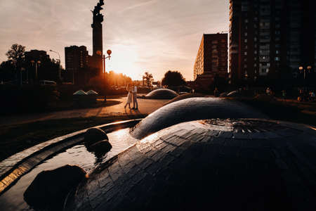 a young couple embraces in the city at a beautiful sunset, urban styleの写真素材