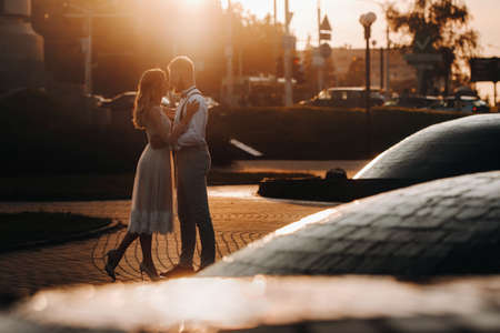 a young couple embraces in the city at a beautiful sunset, urban styleの写真素材