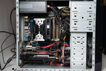 The system unit of the computer is disassembled without a cover.Lots of old computer parts. computer...