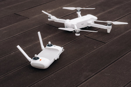 The remote control of the quadcopter is white and the quadcopter is on a wooden background.flight controller on an old wooden background. The view from the topの写真素材