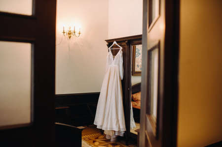 Vintage Wedding dress hanging on a wooden hanger.の写真素材