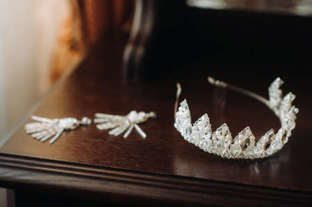 Wedding crown for the bride and earrings lie on the trellis.の写真素材