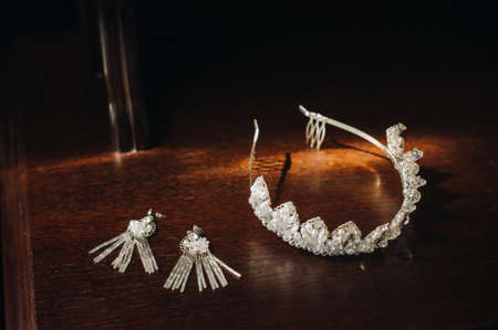 Wedding crown for the bride and earrings lie on the trellis.の写真素材