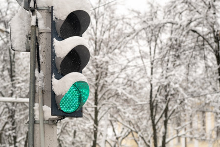 A working traffic light on a city street in winter.The traffic light is green.の写真素材