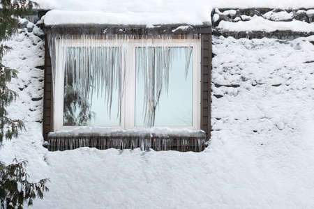Icicles on the window of the house on a frosty day..の写真素材