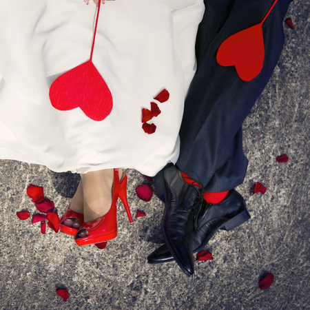Close-up of lovers ' feet and two red hearts lying on them.の写真素材