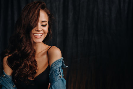 a girl smiles with beautiful white teeth in the studio on a black backgroundの写真素材
