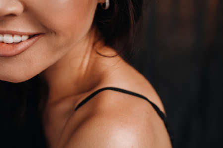 close-up of a girls face smiling in the studio on a black backgroundの写真素材