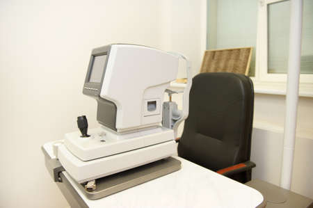 The device for checking the vision of a person is in the office of an optometrist.