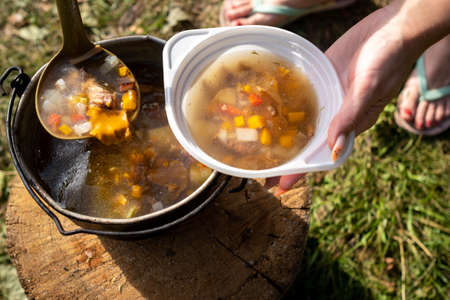 ready mushroom soup cooked over a fire is poured into a plate.