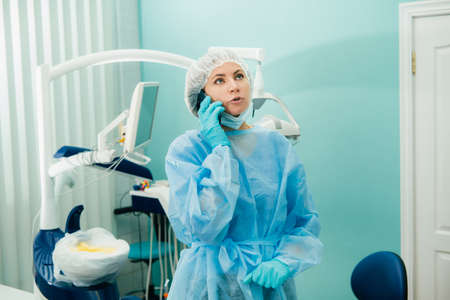 a female dentist is on the phone in her dental officeの写真素材