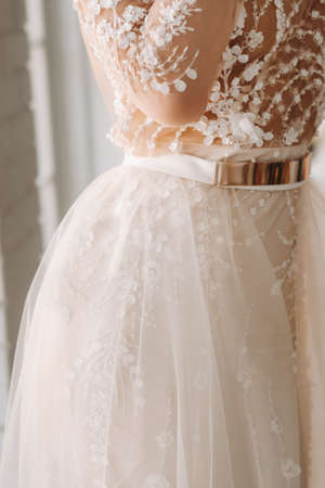 A luxurious bride in a wedding dress in the morning in her interior.
