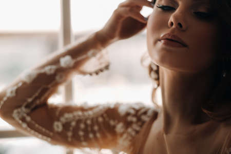 A luxurious bride in a wedding dress in the morning in her interiorの写真素材