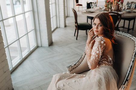 A luxurious bride in a wedding dress in the morning in her interiorの写真素材