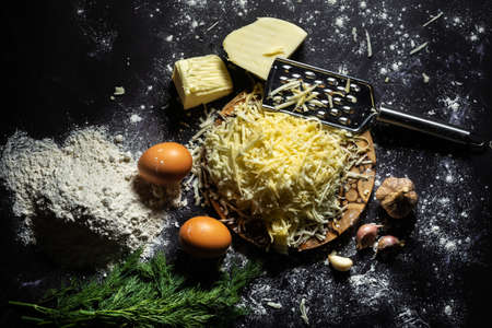 still life of the process of making cheese balls with garlic and dill on a black background.の写真素材